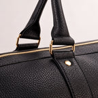 Rolled handles and gold hardware on the Black bag