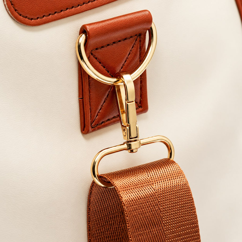 Cognac strap and gold clasp on the Ivory bag